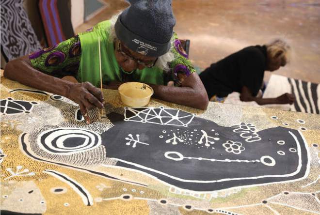 Martha MacDonald Napaltjarri (in foreground) and Mona Nangala painting at Papunya Tjupi art centre, Papunya, 2015. Photo: Helen Puckey